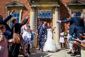 guests celebrate newlyweds photographed by Kelmarsh Hall wedding photographer