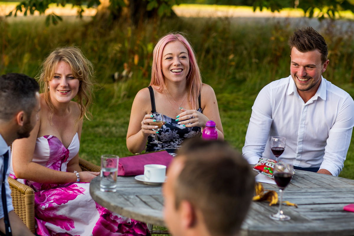 guests sit at table - captured by Kelmarsh Hall wedding photographer