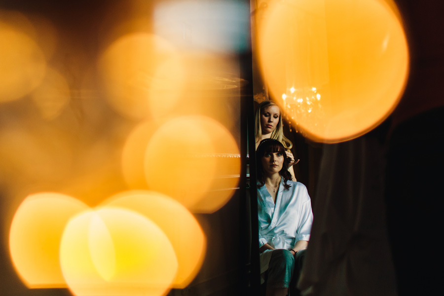 an artistic photograph of a bride receiving her made up