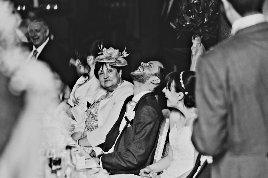 a black and white image of a groom during the wedding speeches