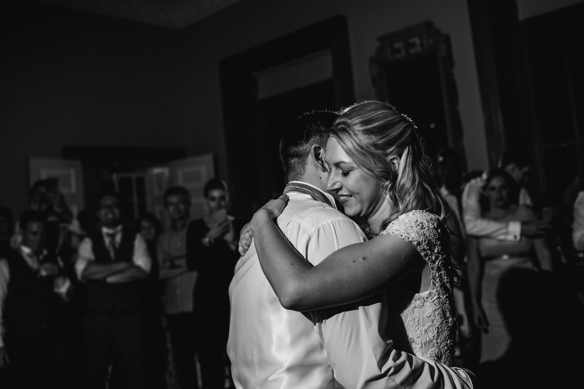 a bride and groom embrace on the dance floor