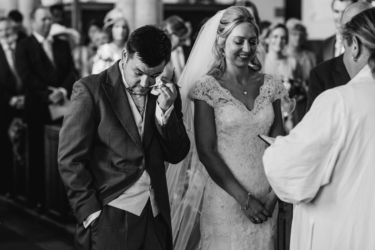 a groom get emotional during a church wedding