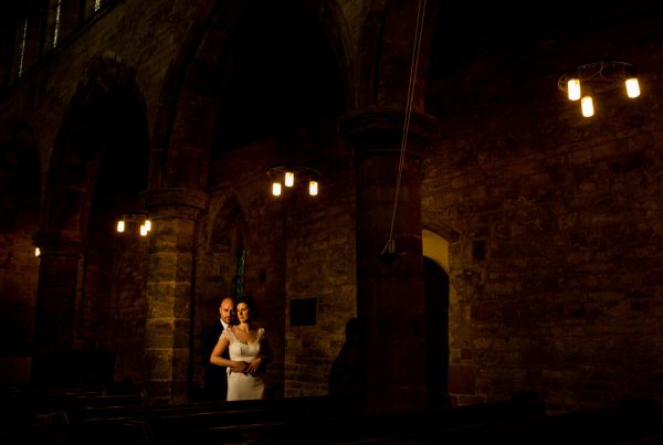 groom and bride in low light church, captured by Cotswold wedding photographer