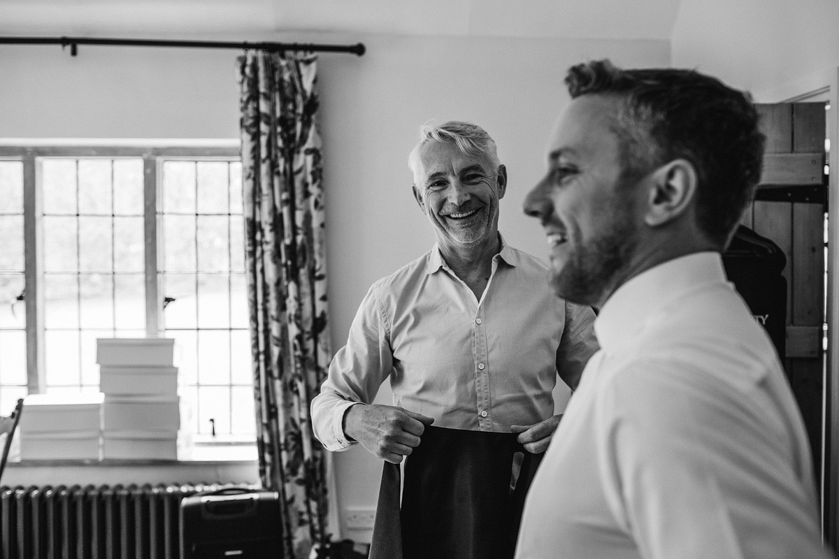 The father of the groom shares a joke with his son