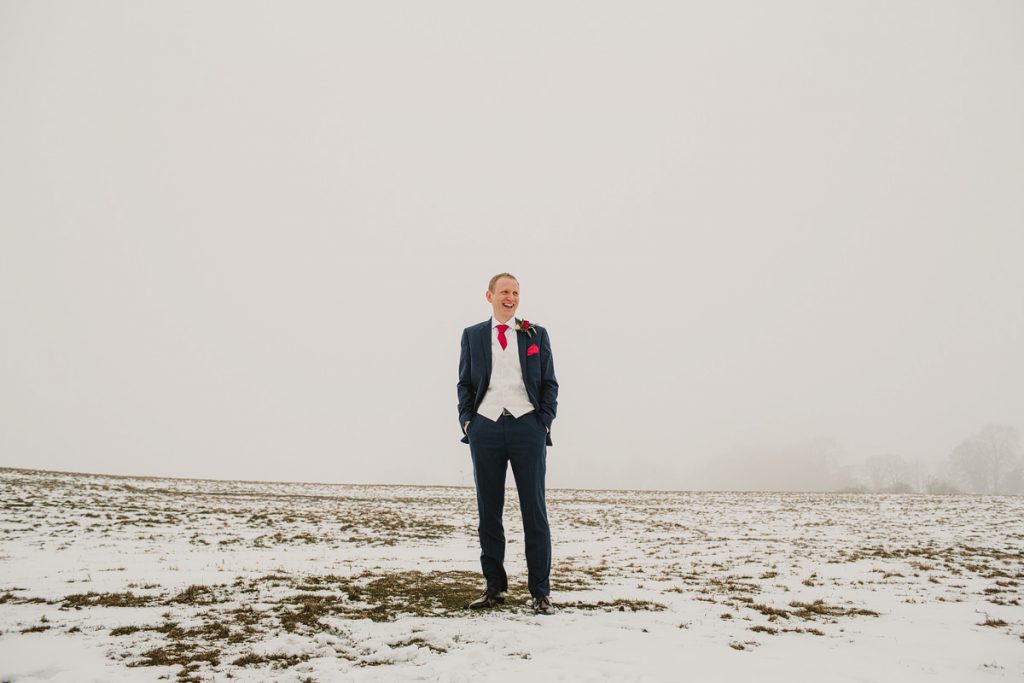 a portait of a groom in the snow