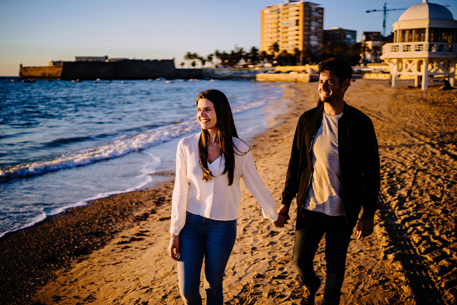 a photograph of a smiling couple on the beach