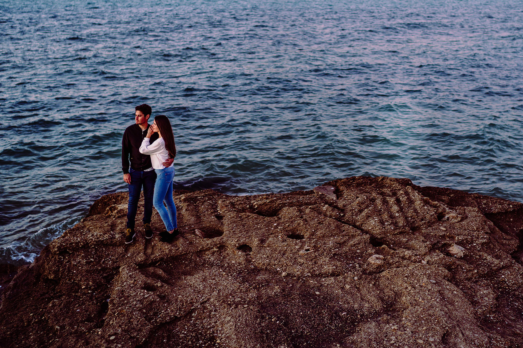 a couple embrace by the sea