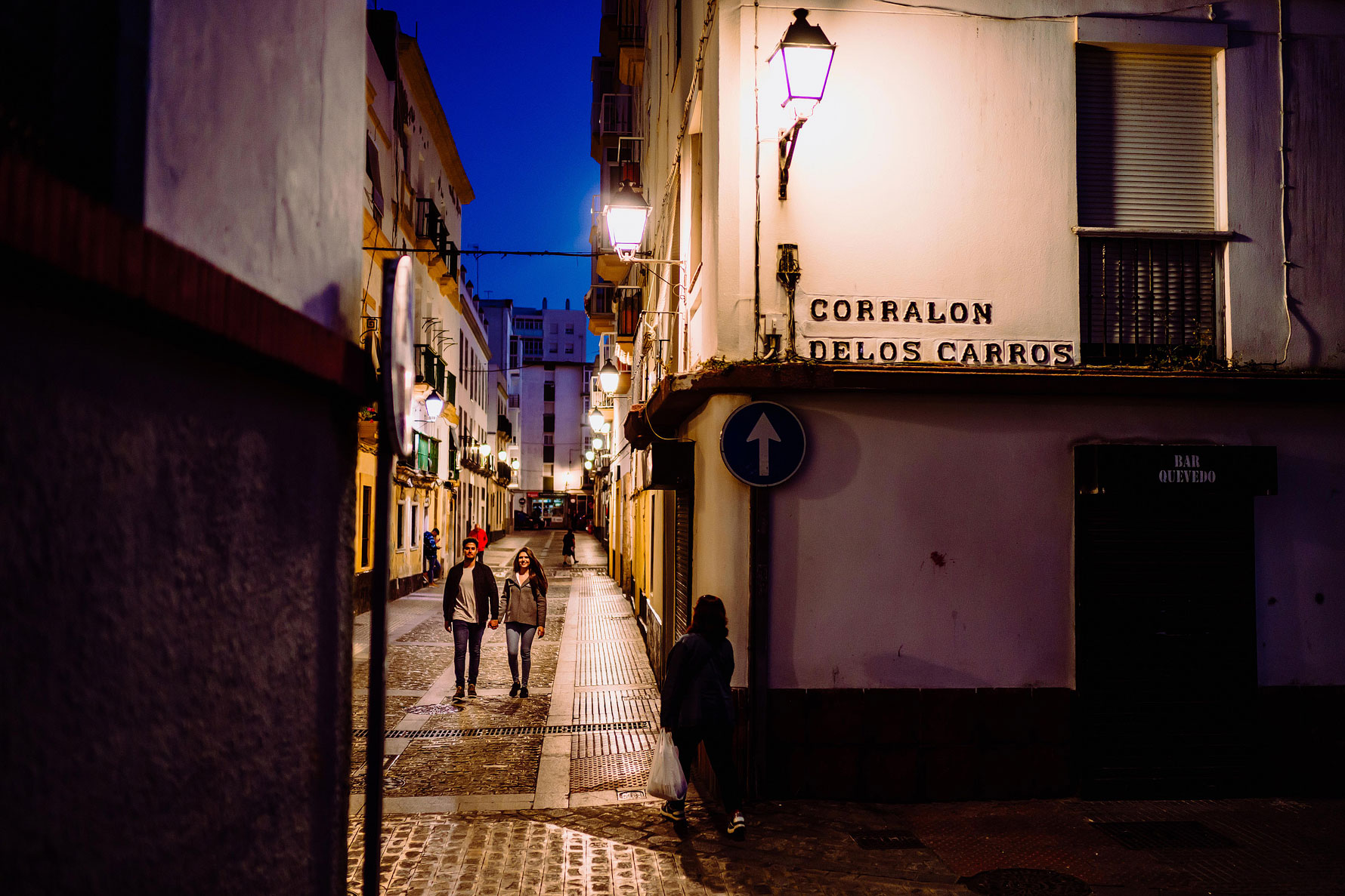 a couple walk through the streets of Cadiz at sunset