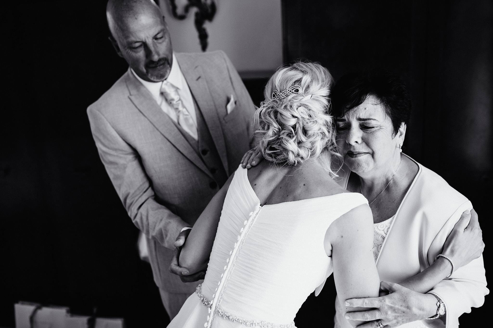 an emotional image of a bride with her parents