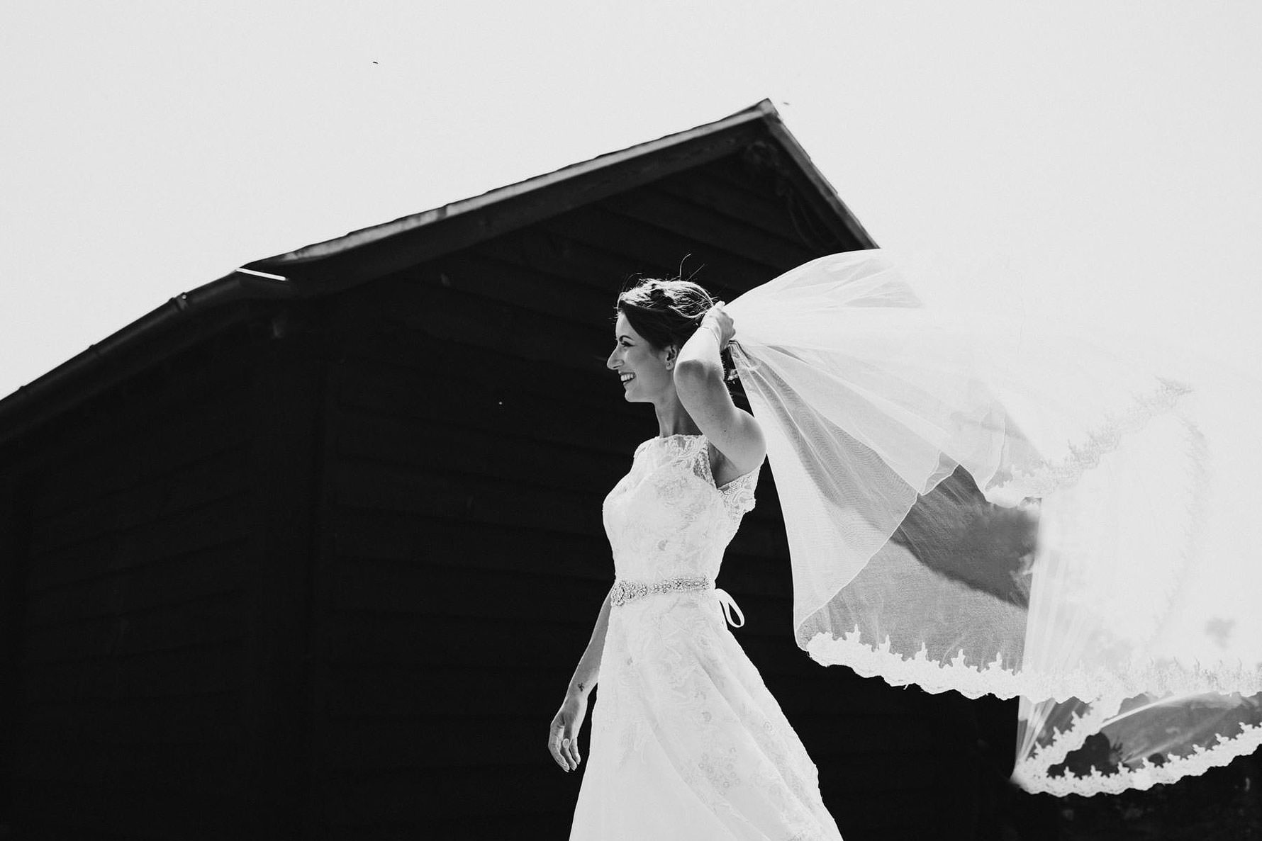 a black and white image of a bride and her veil