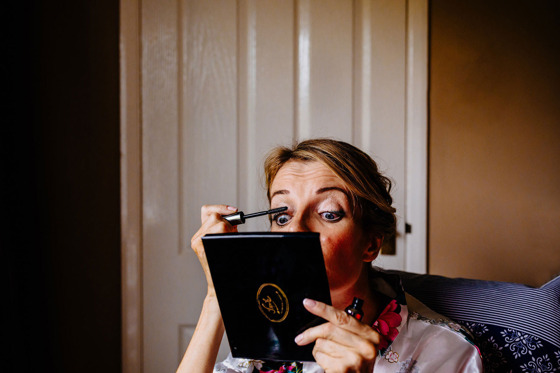 a bride applies her make-up