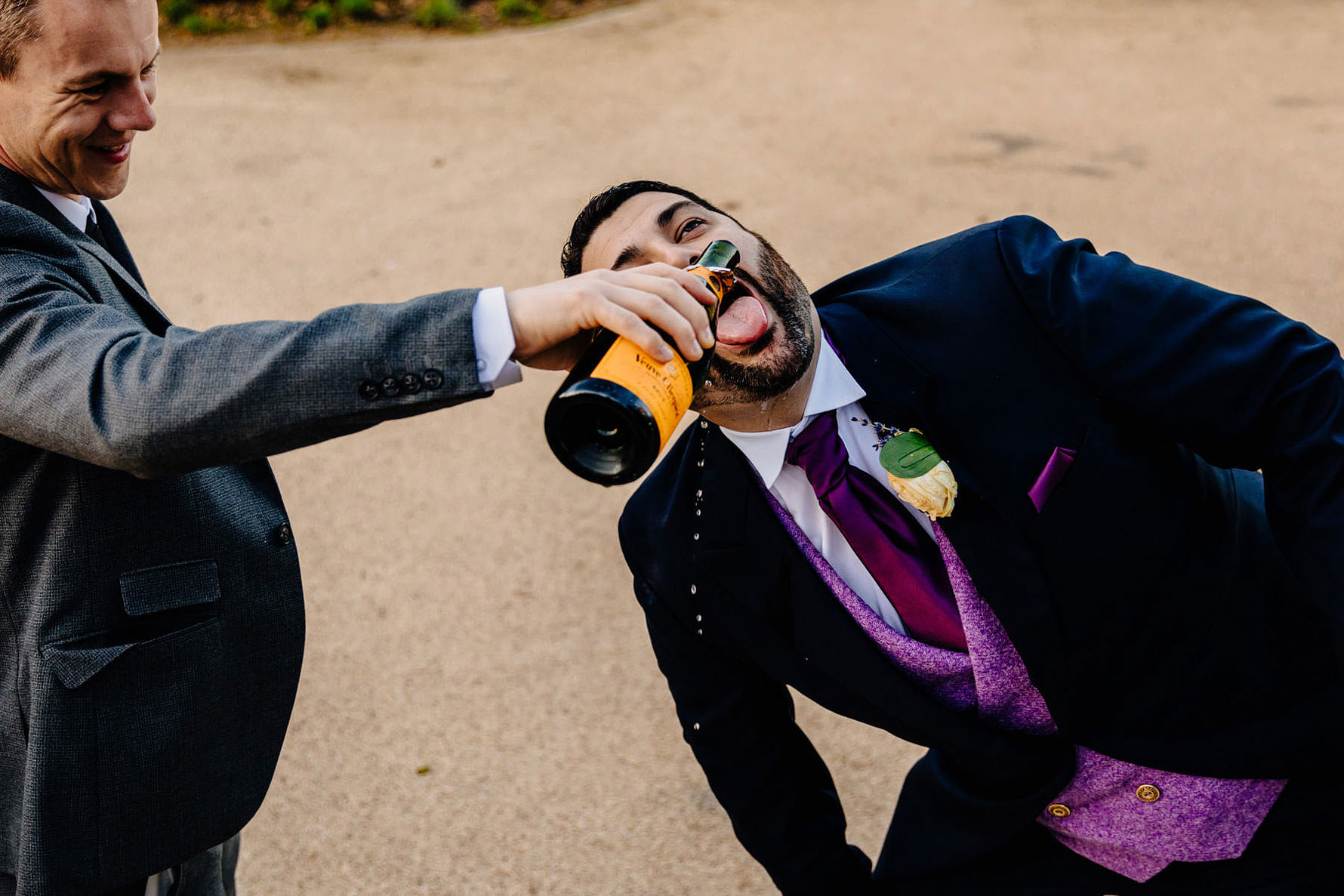 champagne being poured into the grooms mouth