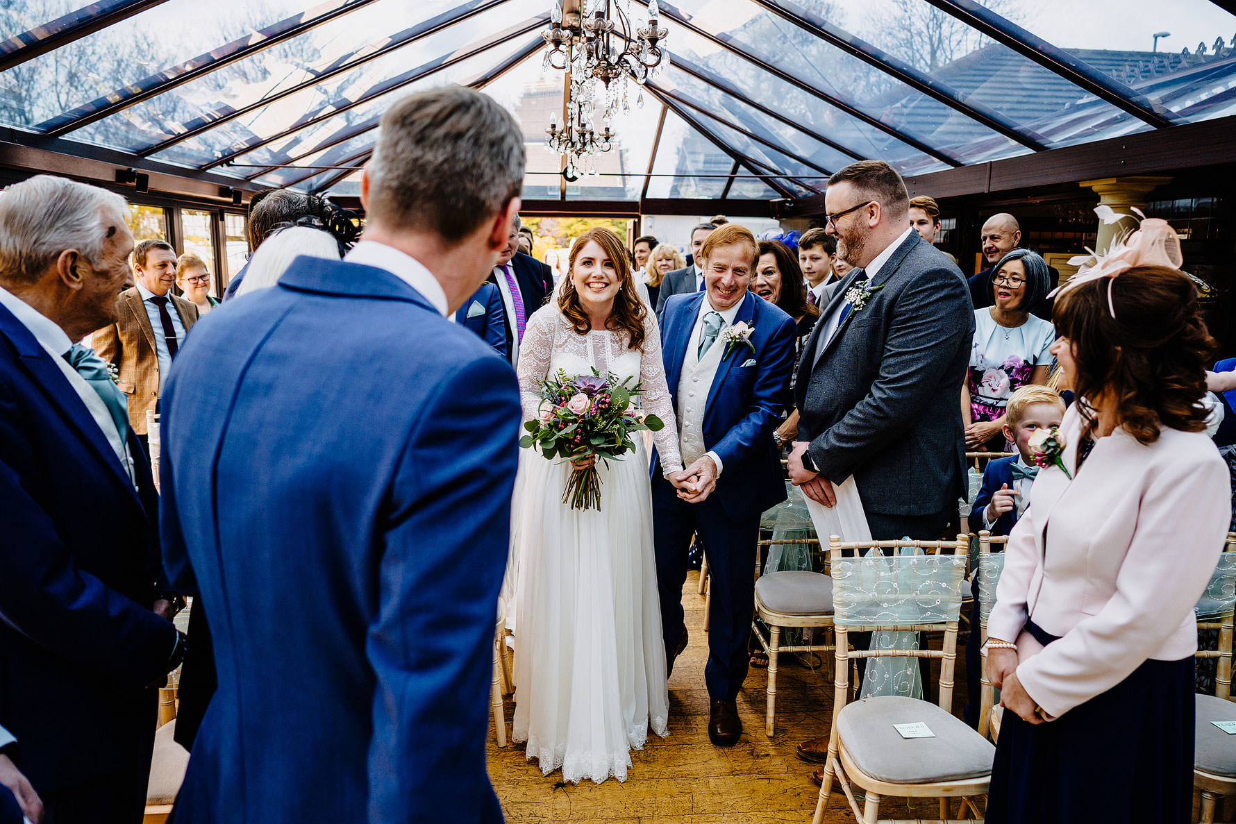 an excited bride walks down the aisle