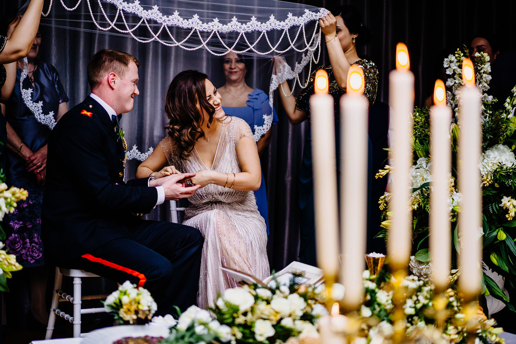 a bride struggles to fit the ring on her grooms finger