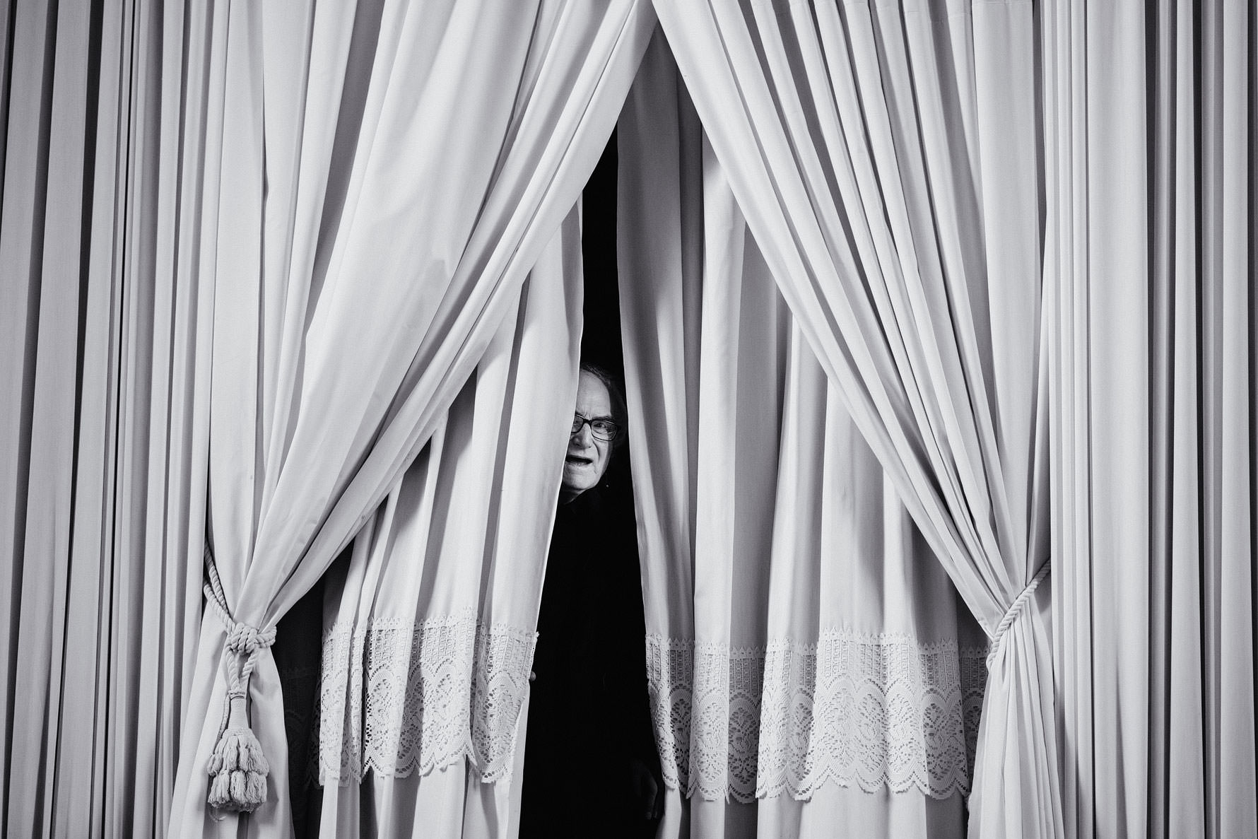 a guest sneaks a peek at the ceremony during a wedding