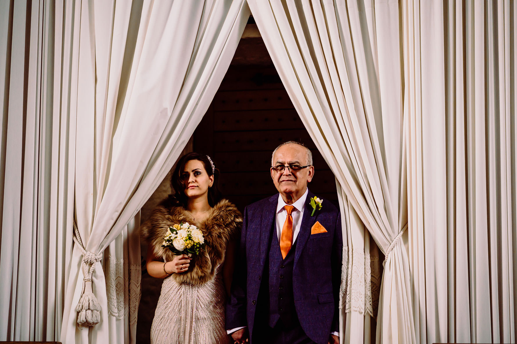 a bride and father of the bride walking down the aisle