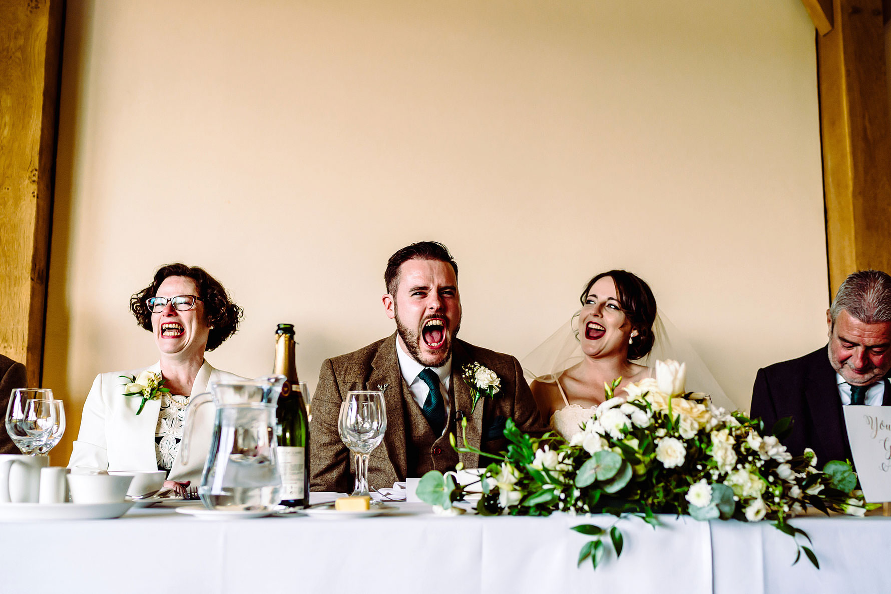 a groom laughs during a speech