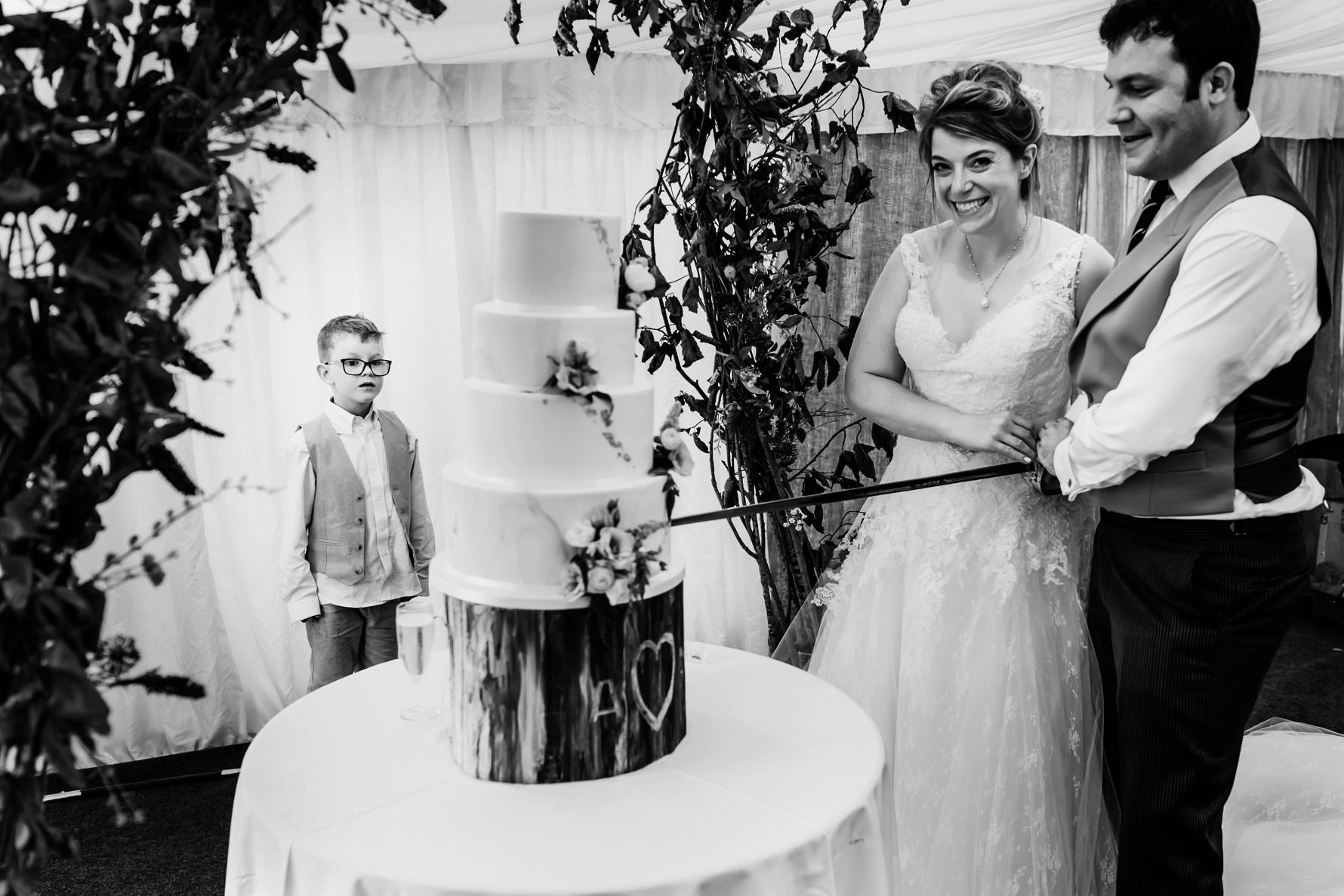 a little boy stares at the wedding cake